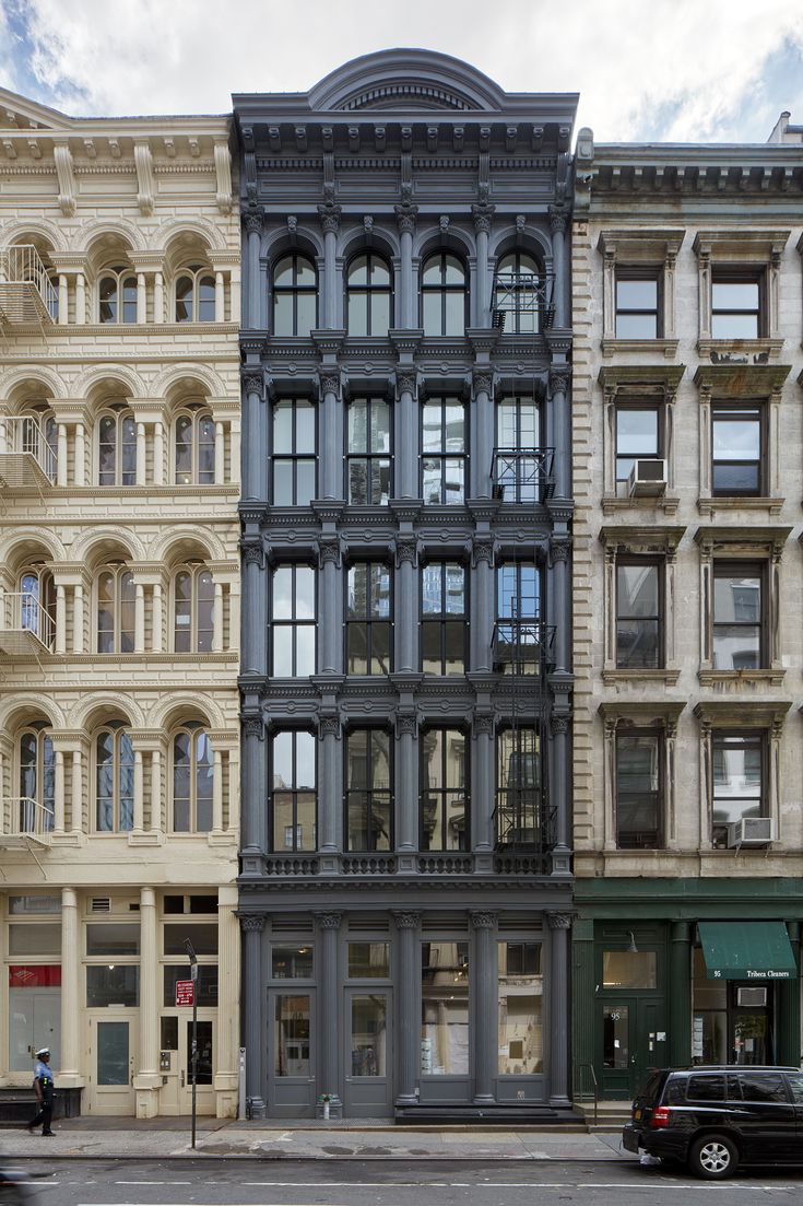 an old building with many windows on the side of it and cars parked in front