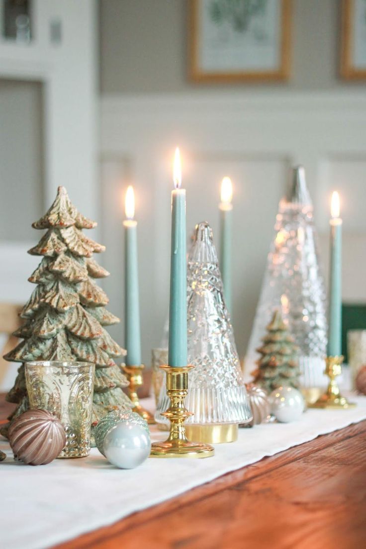 a table topped with christmas trees and candles