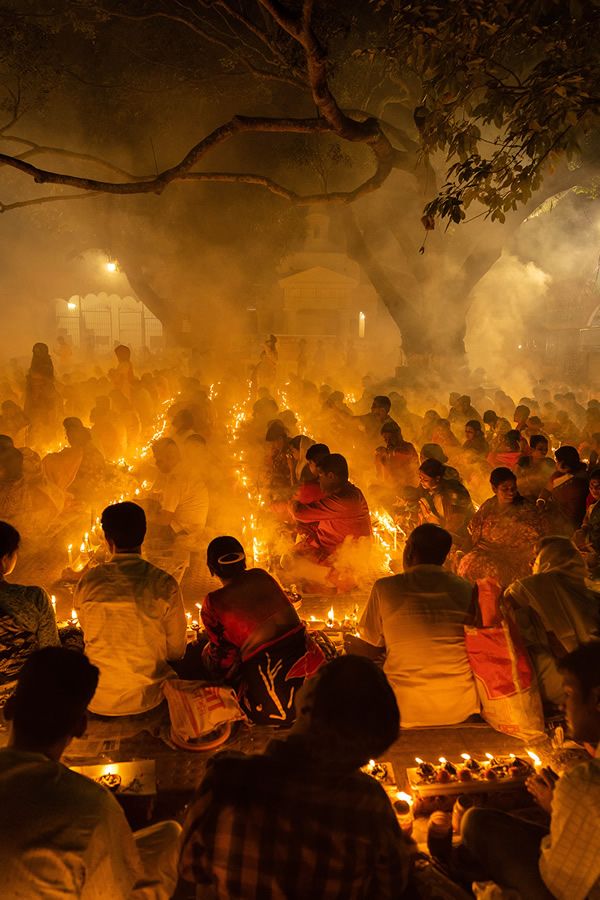 many people are sitting around with candles in their hands as the light shines on them