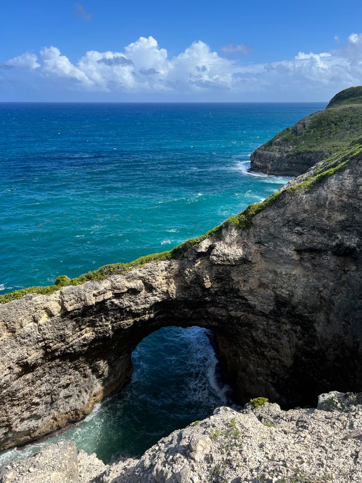 an arch in the rock by the ocean