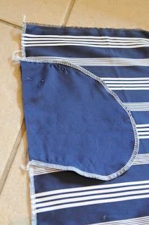 a blue and white striped towel laying on the floor next to a tile floor with a hole in it