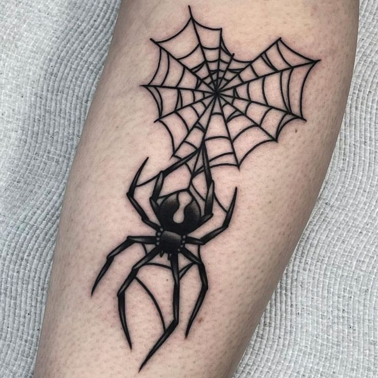 a spider with a web on it's legs is seen in this tattoo design