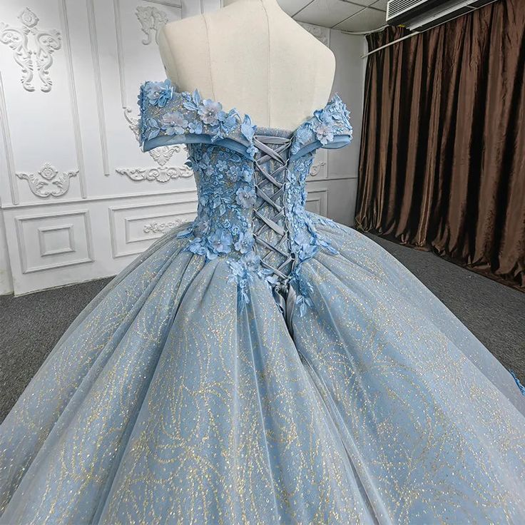 Blue being your choice of hue? Then this party dress is meant for you, possession and adornment of it will make you look like a princess! It comes with a fully trimmed sweetheart bodice with flower accents, together with a sparkling glitter gold overlay that adds an aura of elegance to the full gathered skirt leading to a back train, allowing for an easy adjustable fit through its corset-style lace up back. material: organza color: as shown type: party ball gown sweetheart neckline built in bra Quinceanera Blue, Quinceanera Dresses Red, Champagne Quinceanera Dresses, Blue Ball Gown, White Quinceanera Dresses, Purple Quinceanera Dresses, Black Quinceanera Dresses, Quinceanera Dresses Gold, Quinceanera Dresses Pink