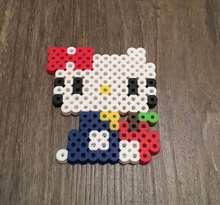 an image of a hello kitty made out of legos on the floor in front of a wooden table