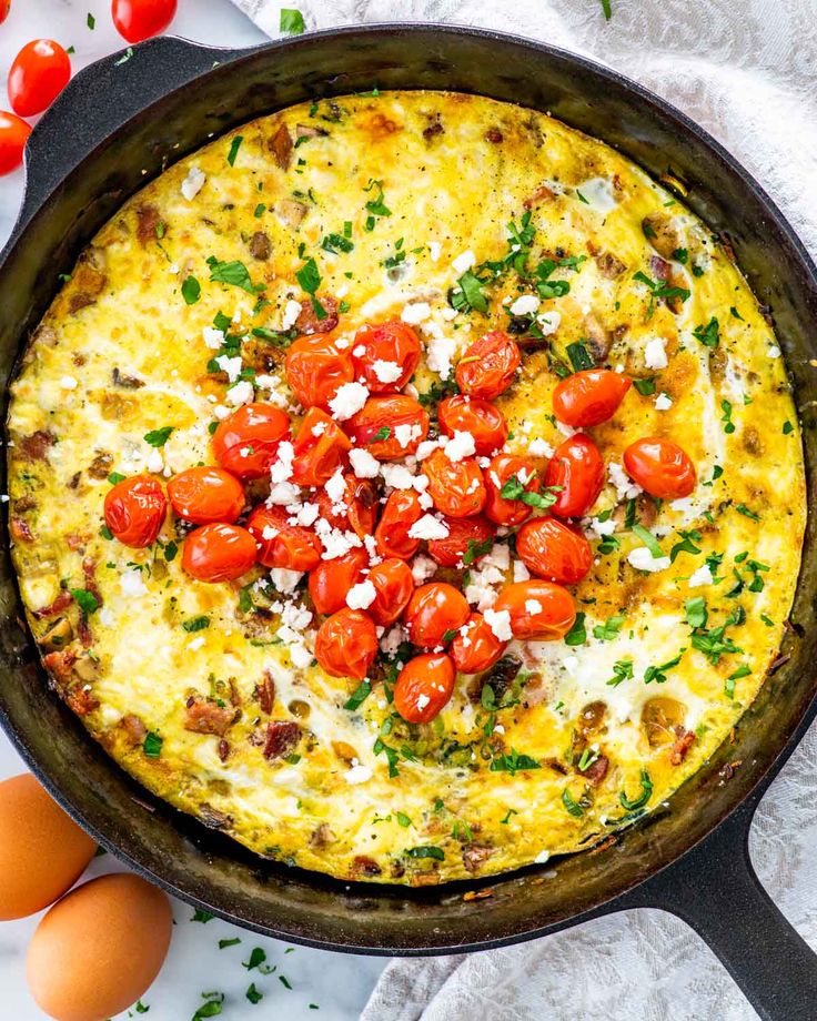 an omelet with tomatoes and cheese in a skillet