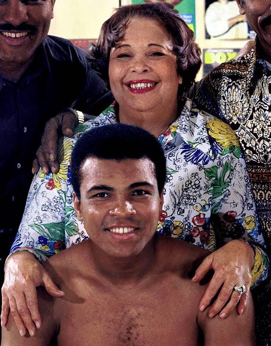 two men and a woman are smiling for the camera while one man has his shirt off