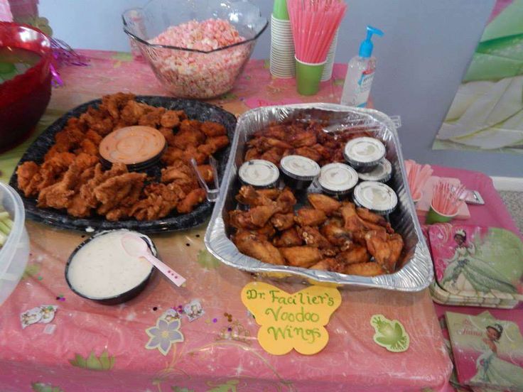 two trays filled with food sitting on top of a pink tablecloth covered table