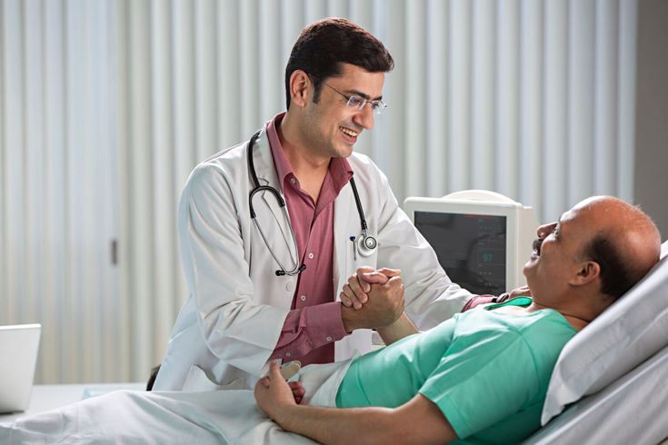 a man in a hospital bed being examined by a doctor