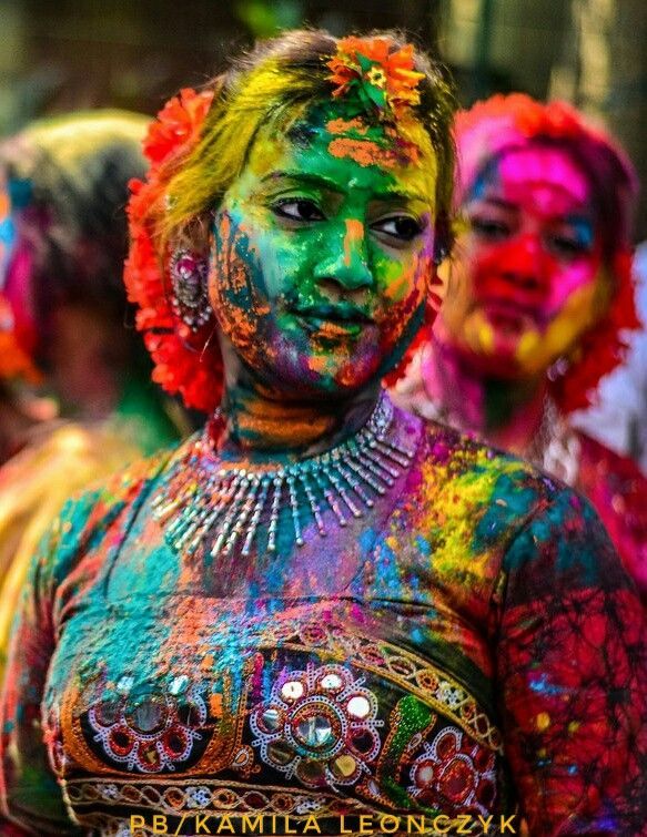 people are covered in colorful paint and posing for the camera