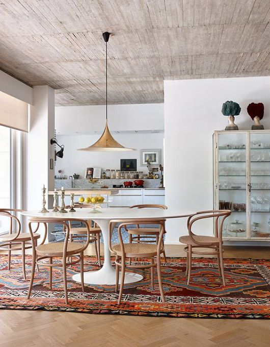 a dining room table with chairs and an area rug on the floor in front of it