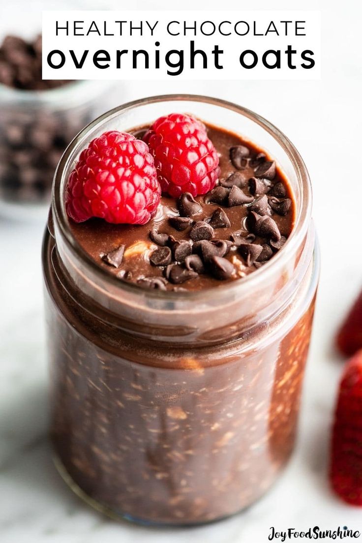 chocolate overnight oats in a mason jar with raspberries and chocolate chips on the side