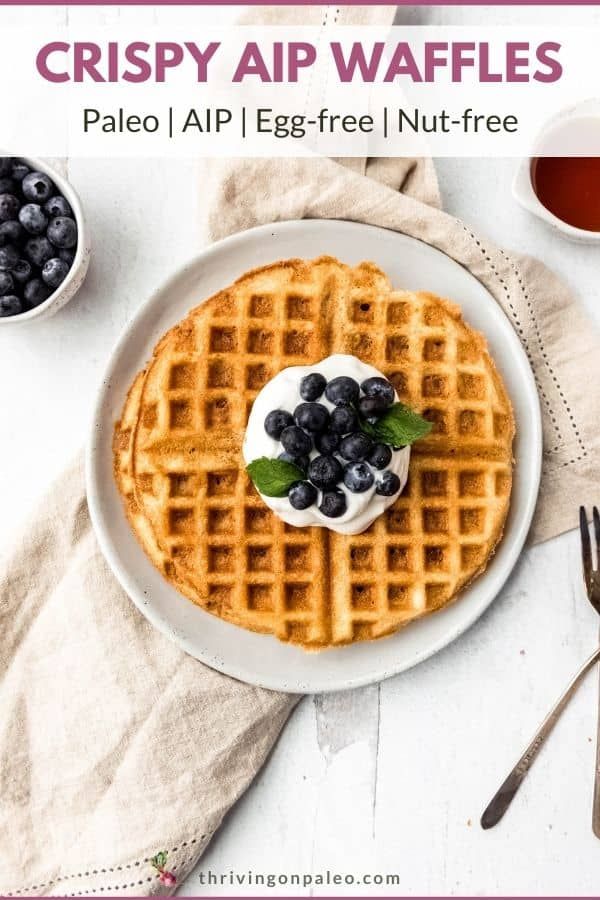 a white plate topped with waffles covered in blueberries