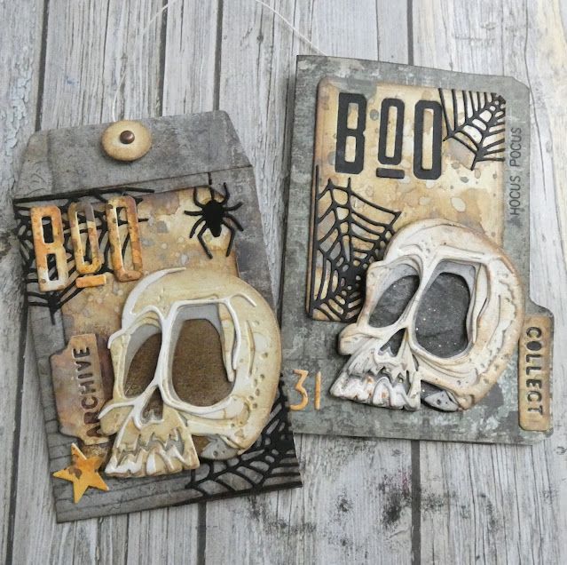 two halloween tags with skulls and spider webs on them sitting on a wooden surface