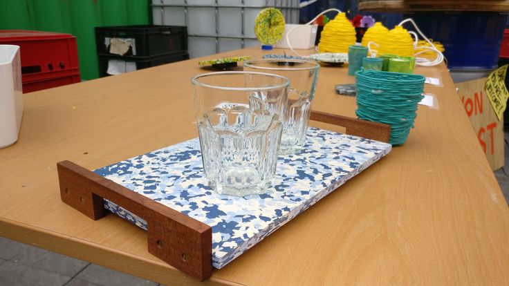 a wooden table topped with glasses on top of a blue and white cloth covered tray