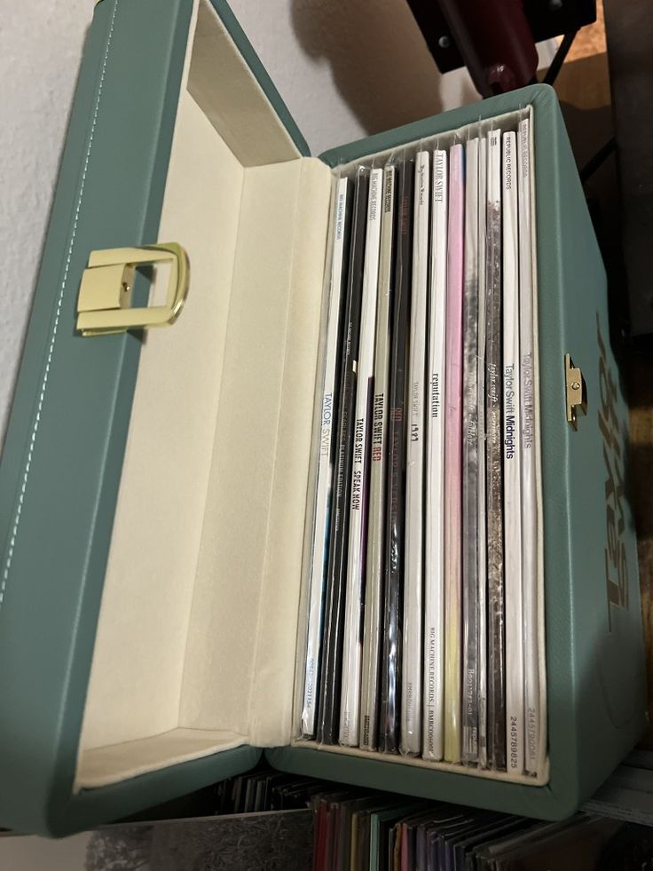 an old record player is open to show the vinyls in it's storage compartment