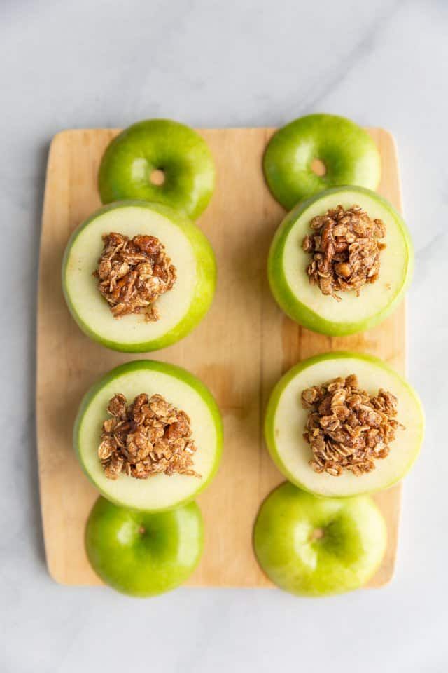 apples with granola in the middle on a cutting board