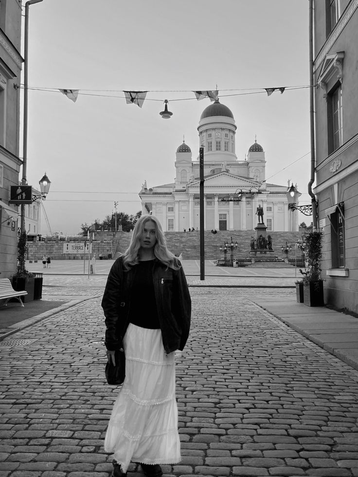 a woman standing in front of a large building