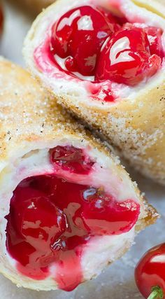 two cranberry filled pastries on a white plate next to some strawberries