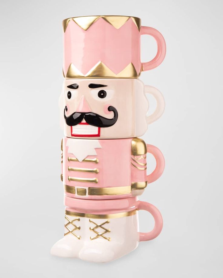 a pink and gold coffee cup with a mustache on it's head, in the shape of a nutcracker