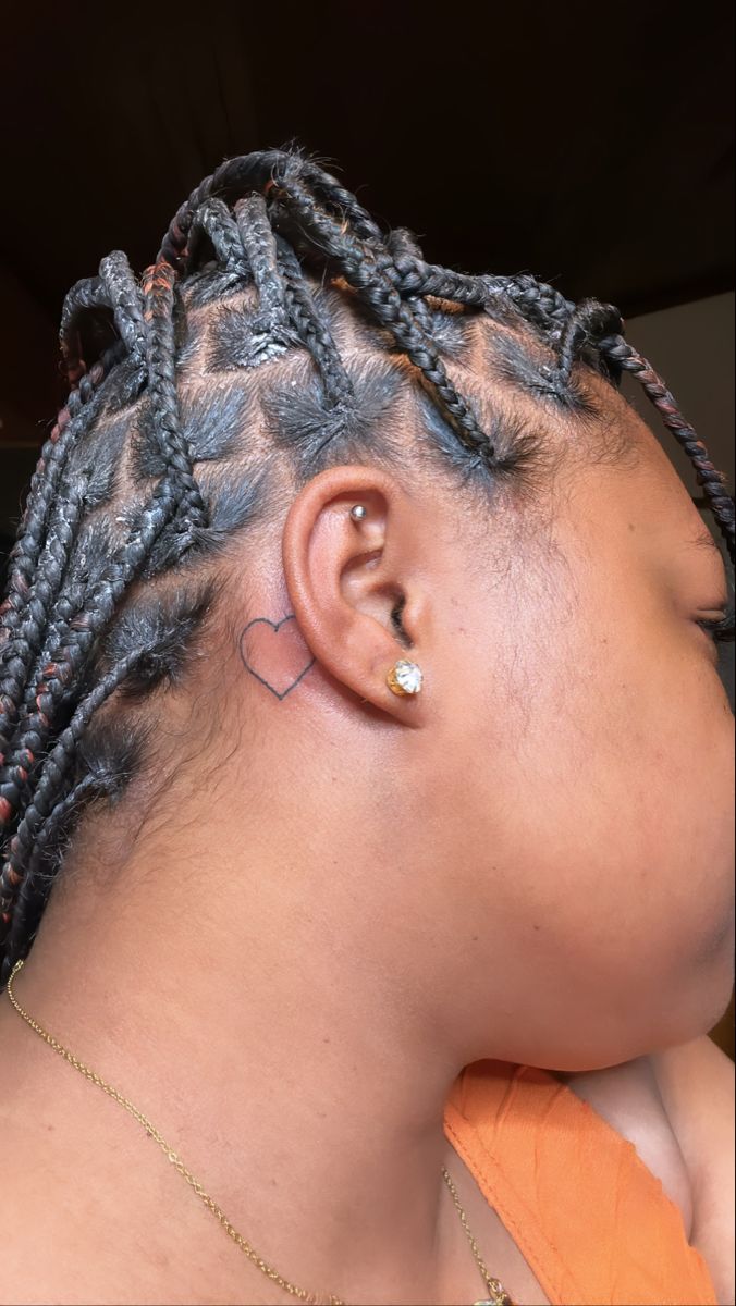 a close up of a person with dreadlocks and an ear piercing on their head