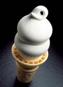 an ice cream cone with a white frosting on it's top and a black background