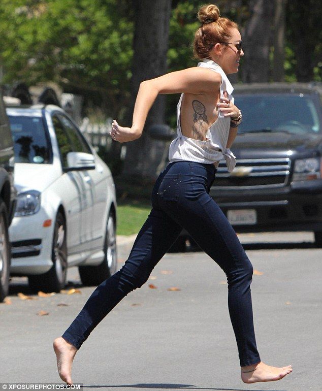 a woman running in the street with her shirt off