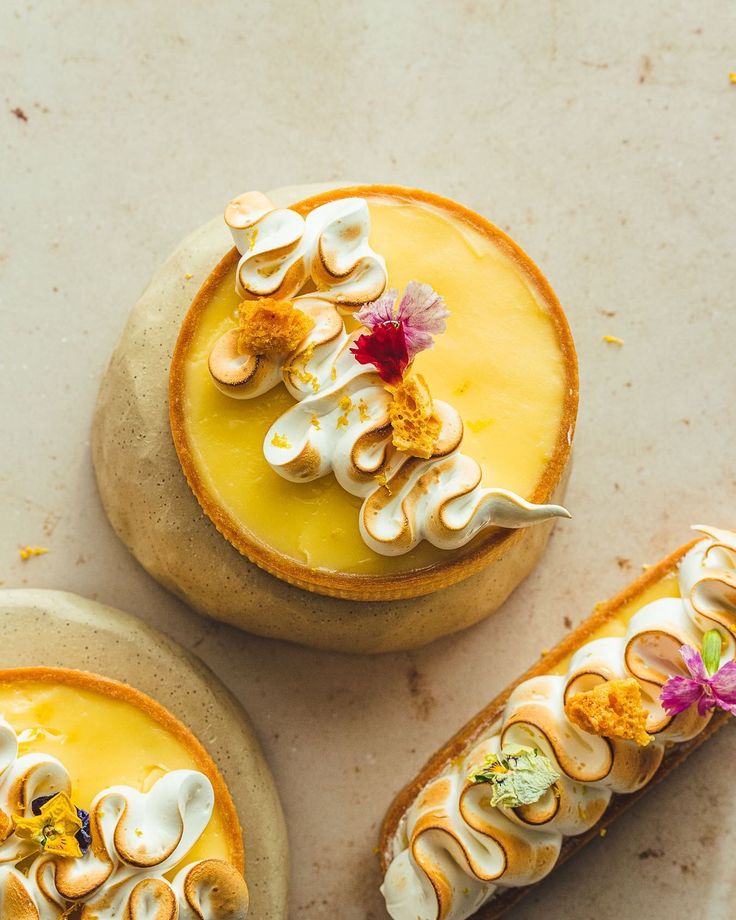 three desserts are arranged on top of each other, with flowers in the middle