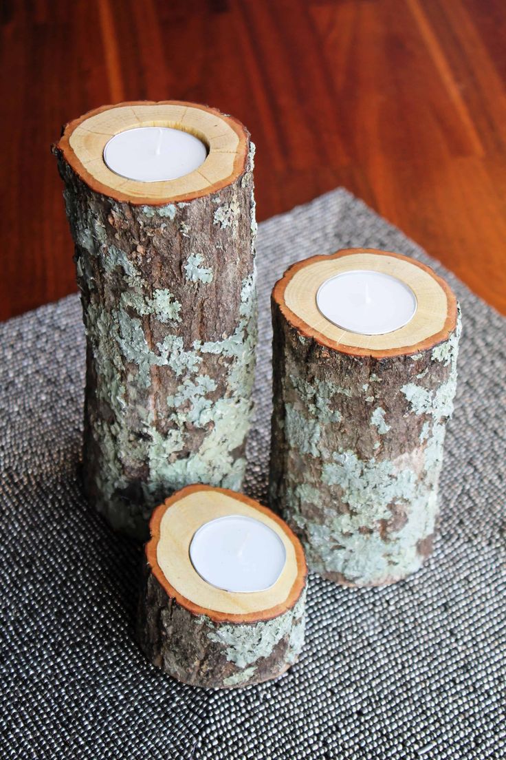 three candles are sitting on top of some wood logs that have been cut in half