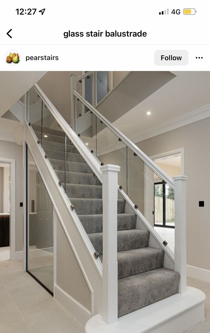 a staircase with glass railing and carpeted steps