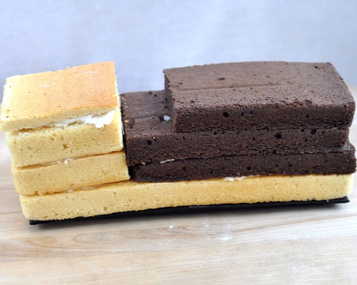 three pieces of brown and yellow cake sitting on top of a wooden table next to each other