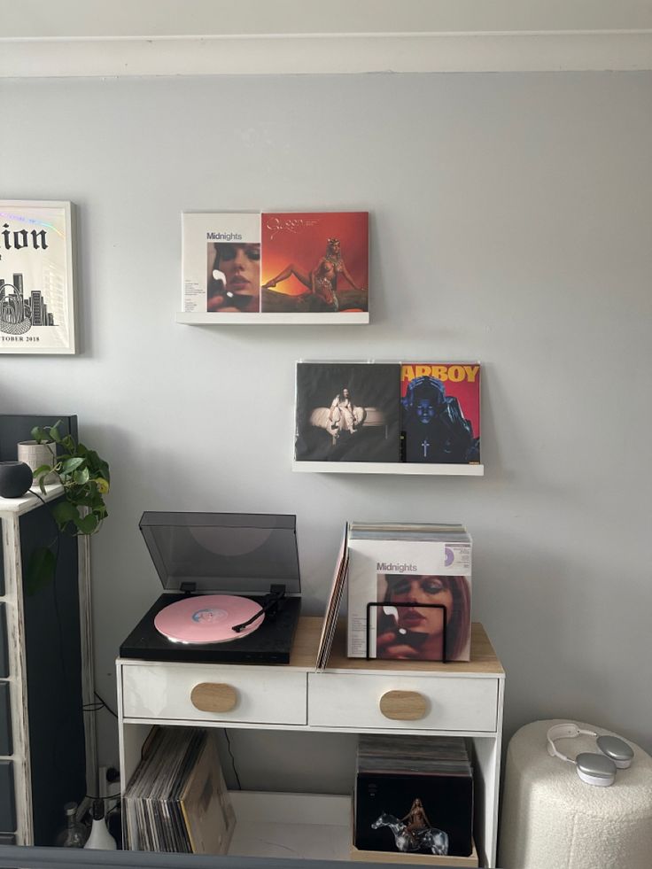 there is a record player on top of a desk in the corner of this room