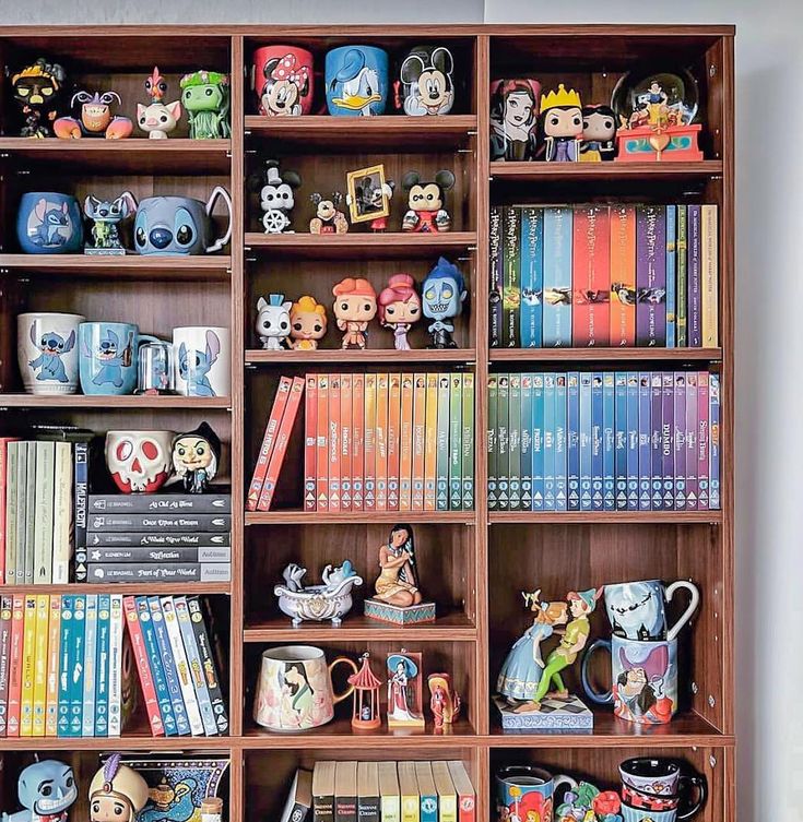 a bookcase filled with lots of books and figurines on top of it