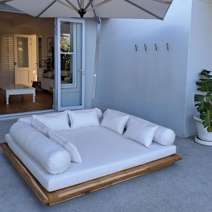 a large white couch sitting under an umbrella