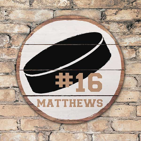 a wooden sign with the number sixteen on it and a hat in front of a brick wall