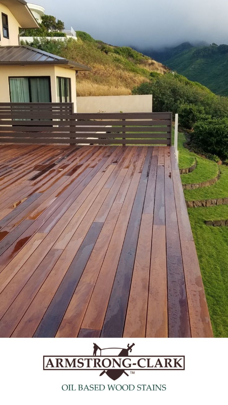 a wooden deck in front of a house with mountains in the backgroung