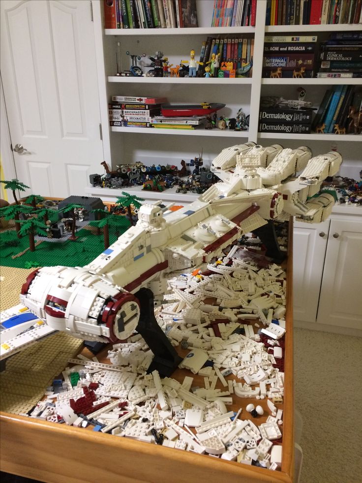 a star wars lego model is on display in a room full of books and toys