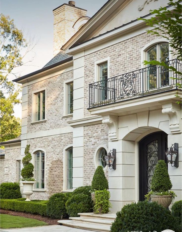 a large white brick house with lots of windows