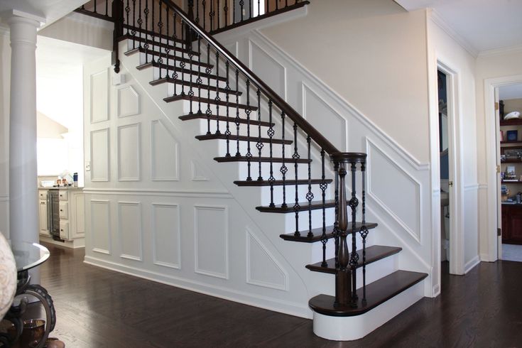 a staircase in a house with white walls and wood floors