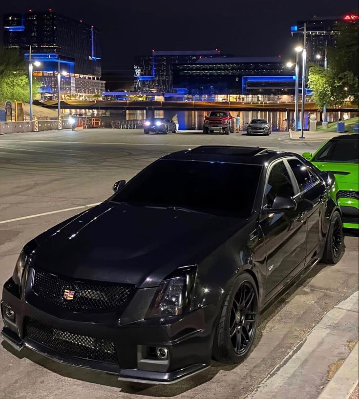 two cars are parked on the street at night