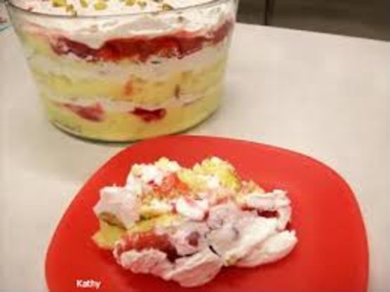 a red plate topped with a dessert next to a large glass bowl filled with fruit