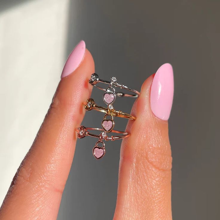 You know you've got the key to our heart! Why not pair it with this adorable locket-inspired charm ring? The Key To My Heart Ring features a whimsical key-like band with a charming baby pink heart shaped locket dangling off of it. Lock this cutie down and tap 'Add to Cart'! 18k gold plated, 18k rose gold plated, or rho Cute Heart Ring For Gift, Pink Adjustable Heart Ring For Promise, Adjustable Pink Heart Ring For Promise, Personalized Pink Heart Ring, Pink Heart Ring For Valentine's Day Proposal, Cute Pink Heart Ring Gift, Cute Pink Heart-shaped Rings, Pink Double Heart Jewelry For Promise, Dainty Pink Heart Ring For Valentine's Day