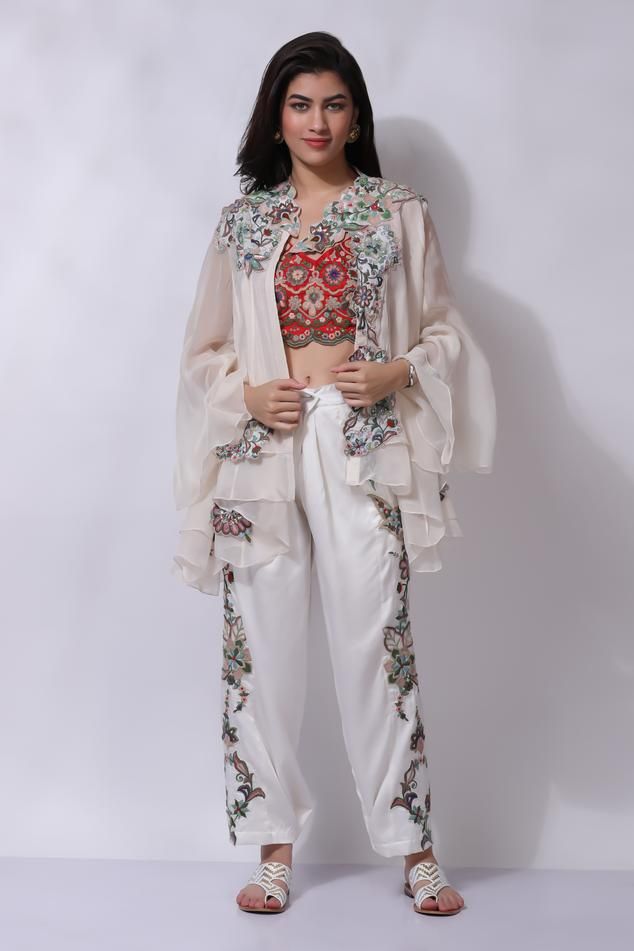 Ivory white floral embroidered jacket. Paired with an inner and embroidered pant.
Components: 3
Pattern: Embroidered
Type Of Work: Chikankari
Neckline: V Neck
Sleeve Type: Flared
Fabric: 25% Silk, 75% Cotton
Color: Ivory,White
Other Details: 
Attached cotton lining
Model Height: 5 ft 7 inches, wearing size M
Closure: Zip
Occasion: Resort - Aza Fashions Eid Sets With Floral Embroidery And Front Open Design, Eid Front Open Sets With Floral Embroidery, Traditional Drape Sets With Floral Embroidery In Cream, Spring Long Sleeve Sharara With Floral Embroidery, Long Sleeve Floral Embroidered Sharara For Spring, Cream Sets With Floral Embroidery And Traditional Drape, Spring Long Sleeve Floral Embroidered Sharara, Designer White Sharara With Floral Embroidery, White Palazzo Set With Chikankari Embroidery For Spring