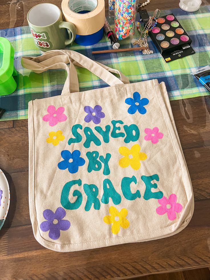 a bag that says saved by grace with flowers on it and other crafting supplies