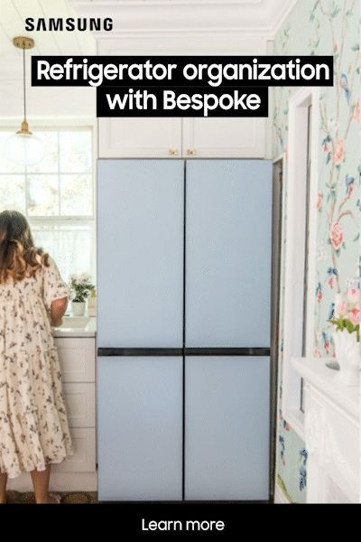 a woman standing in front of a refrigerator