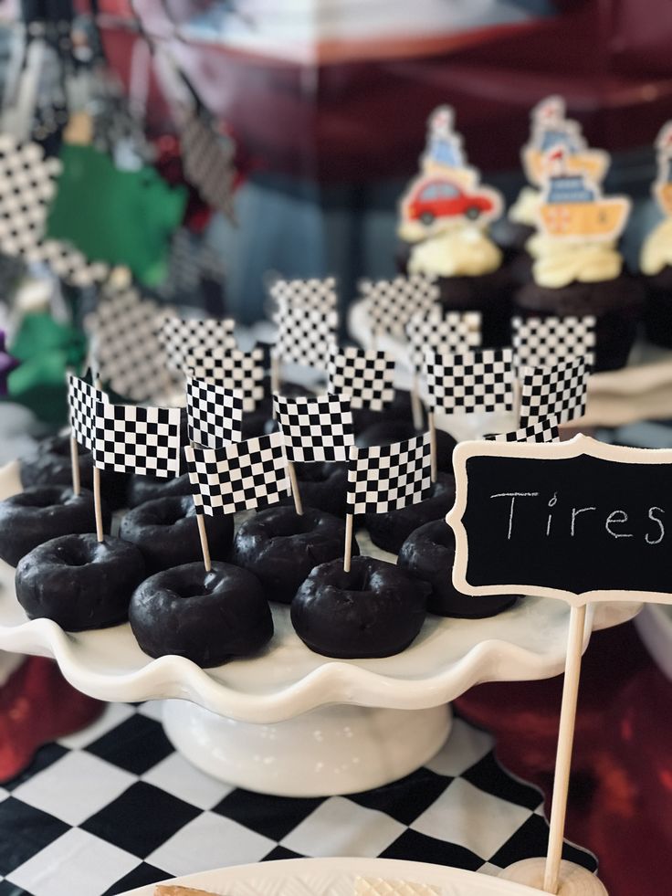 there are many desserts on the table with black and white checkerboard flags