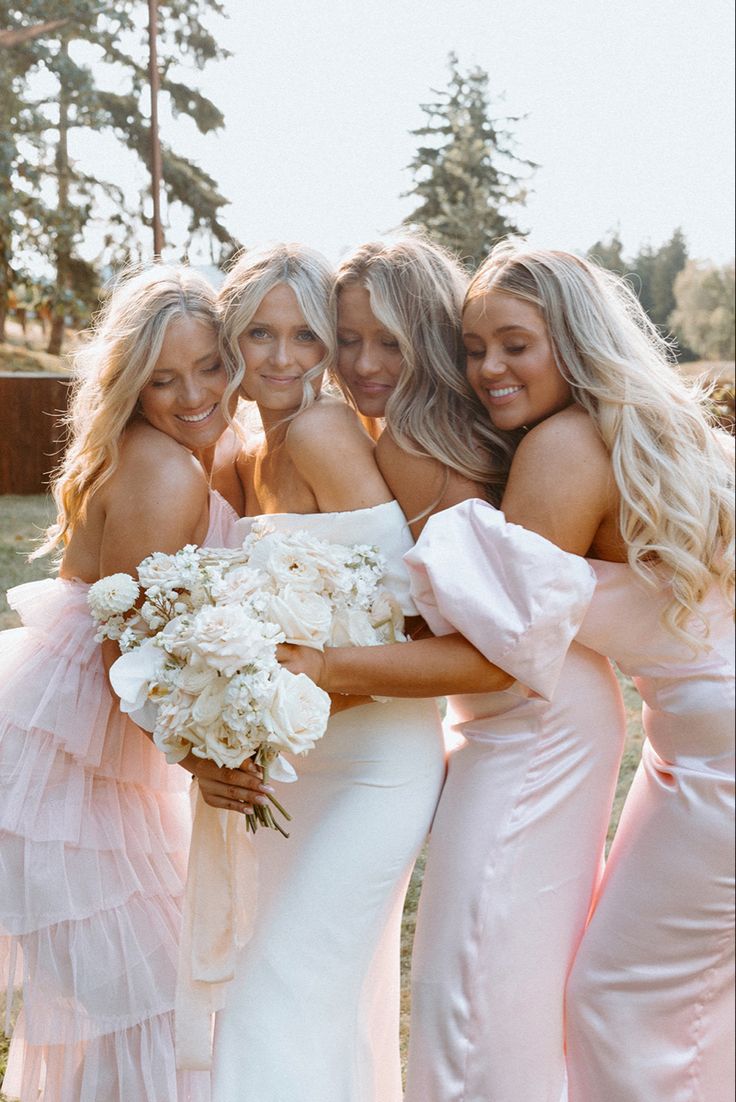 the bridesmaids are all dressed in pink gowns and holding their bouquets