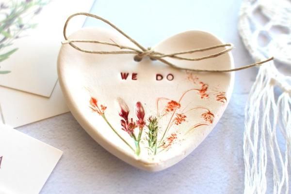 a ceramic heart with the words we do written on it and flowers painted on it