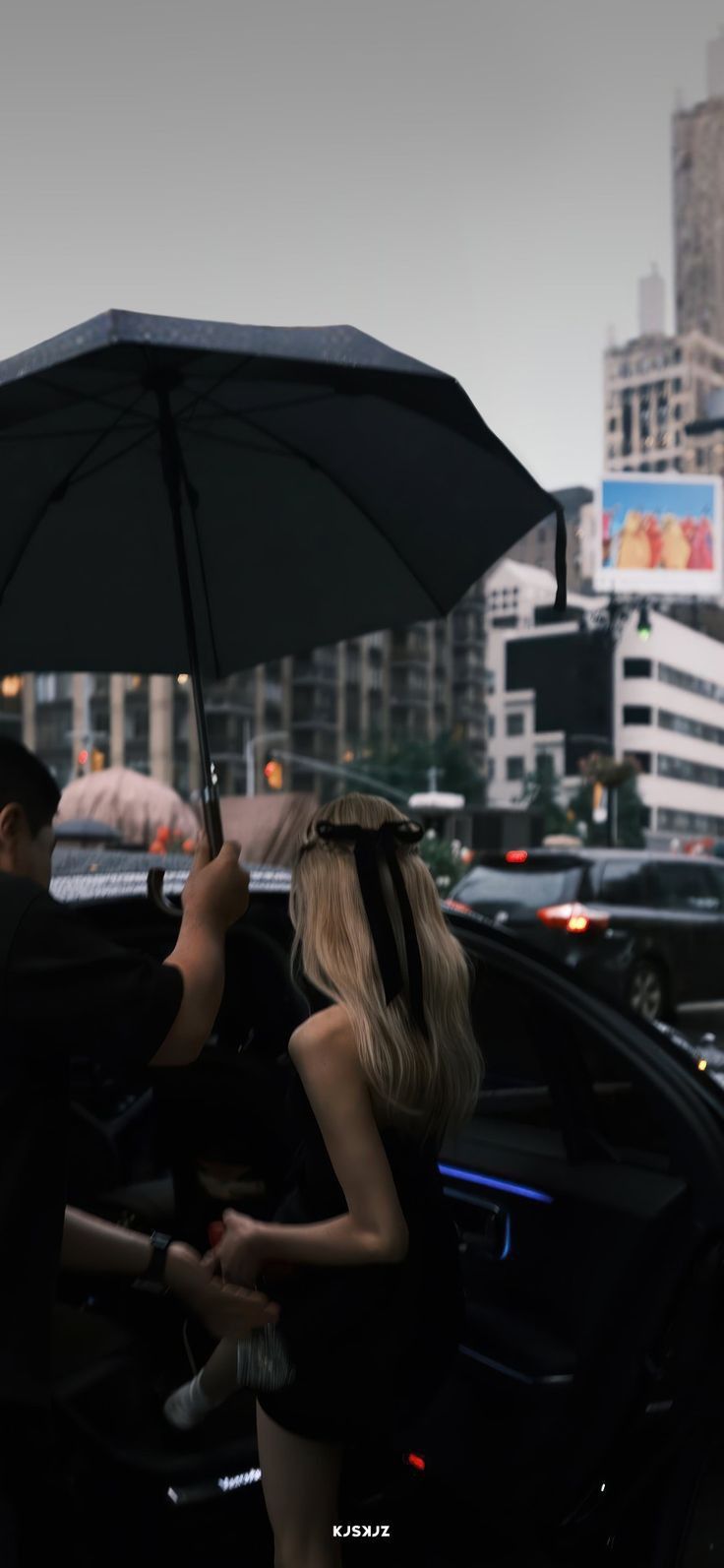 a woman holding an umbrella while standing next to a man