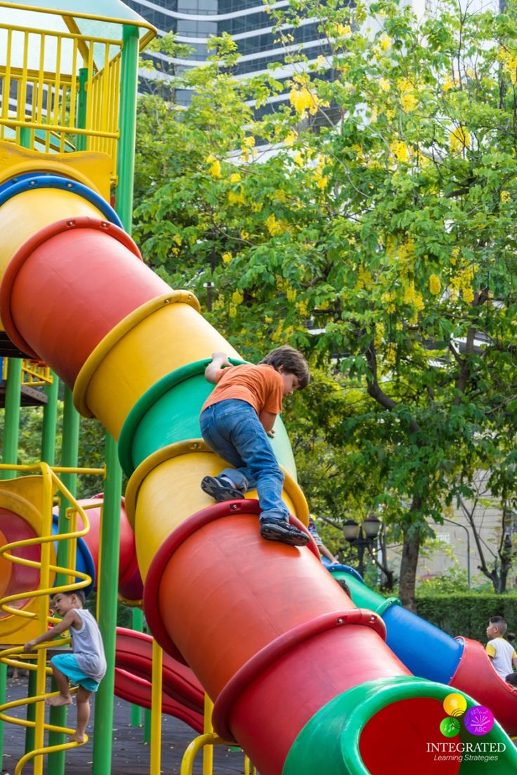 a man is climbing up the side of a colorful slide