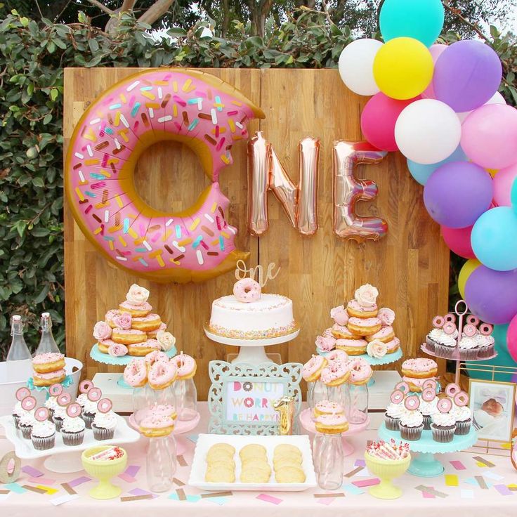 a table topped with donuts and desserts next to a sign that says one